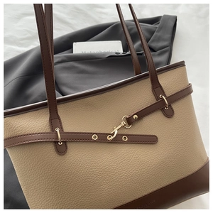 Close-up of contrast large tote bag featuring lychee grain leather and gold metal buckle