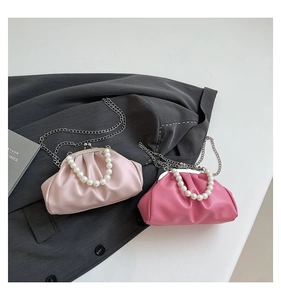 Detail of pink pleated cloud bags with large pearl handles and silver metal chains