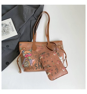 Detail view of brown leather tote bag set featuring colorful graffiti prints and bear motifs