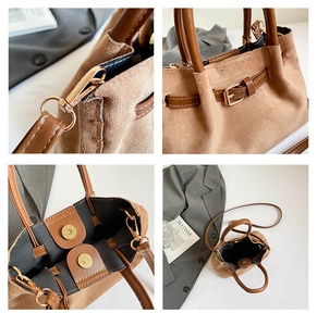 Detail view of brown suede bucket bag with magnetic closure and hardware buckles