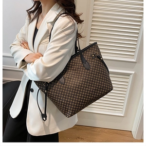Side view of large printed tote bag on shoulder, showing vintage brown pattern and size