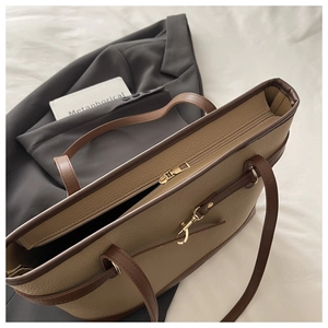Detailed macro view of khaki leather tote with gold hardware and smooth zipper