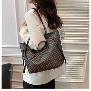 Detail view of large printed tote bag with leather handles and gold metal hardware