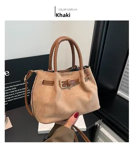 Detail view of khaki bucket bag showing suede texture and brown leather strap with metal buckle