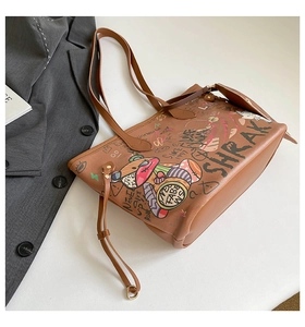 Detail of graffiti print tote bag featuring a cartoon bear and urban street style patterns