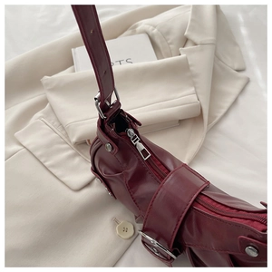 Macro detail of wine red retro pleated bucket bag with shiny faux leather and silver hardware