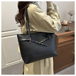Close-up of black leather tote bag with lychee texture and metal hook detail