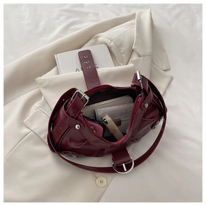 Deep red moto-style handbag showing spacious interior with phone and wallet inside