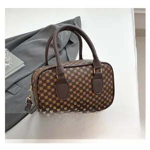 Detail shot of vintage brown monogram PU leather handbag with dual handles and gold hardware