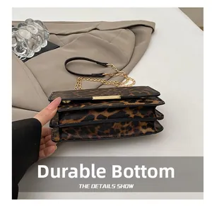 Detail showing the leopard print bag's triple-layered structure and gold chain strap
