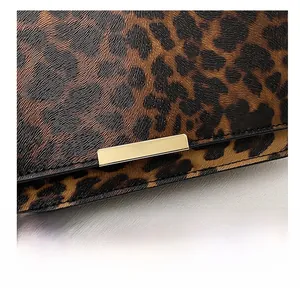 Detail shot of leopard print handbag featuring a premium gold rectangular metal buckle