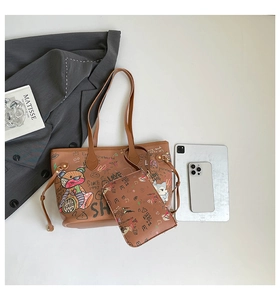 Detail of brown tote bag set featuring graffiti prints with matching small clutch bag