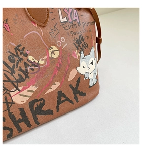 Detail of the brown graffiti tote bag featuring textured leather and artistic prints