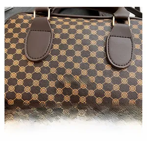 Macro detail of textured brown faux leather bag with clover pattern and gold logo