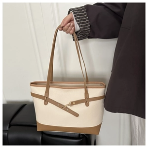 Close-up of contrast color tote bag showing lychee grain leather and gold metal buckle
