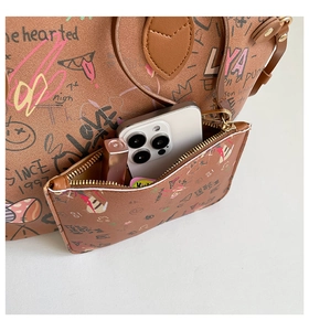 Detail of graffiti tote bag with inner pouch showing storage for phone and lipstick