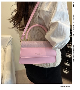 Detail of pink crossbody bag with purple rhinestones and adjustable strap on model