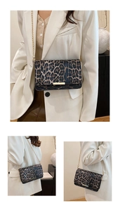 Detailed close-up of leopard print shoulder bag with gold chain strap and metal buckle