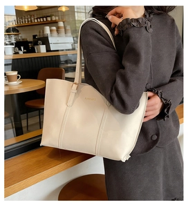 Close-up of beige tote bag with Fashion & Bags text in a cozy cafe setting