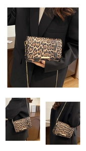 Detailed close-up of leopard print crossbody bag with gold chain and metal trim