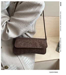 Detail view of leopard print baguette bag with brown matte finish and slim shoulder strap