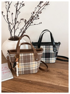 Close-up of British style plaid bucket bags with leather handles and beaded charms
