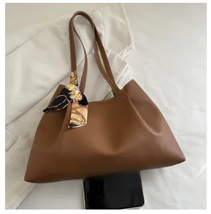Vue de dessus du cabas marron en similicuir avec foulard décoratif et comparatif de taille