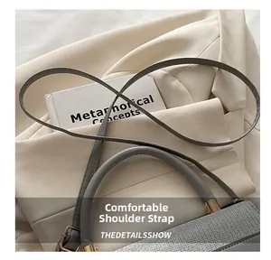 Close-up of comfortable grey leather strap and handle with elegant gold metal hardware