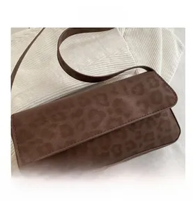 Close-up of leopard print shoulder bag with suede texture and flap closure details