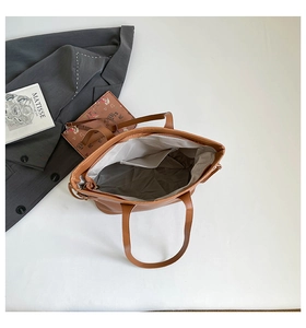 Top view of large brown tote bag showing spacious interior with zip pocket and grey lining