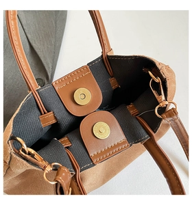 Détail du sac seau en daim marron avec fermeture magnétique et boucles dorées