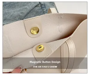 Detail showing the magnetic snap closure and golden hardware on the cream tote bag