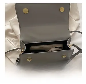 Detail view of the gray crossbody bag interior showing storage space for a smartphone