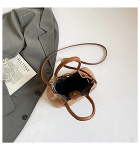 Détail du sac seau en toile et cuir montrant le fermoir magnétique et l'intérieur spacieux