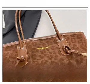 Detail shot of brown leopard print texture and knotted leather handle on a stylish tote bag