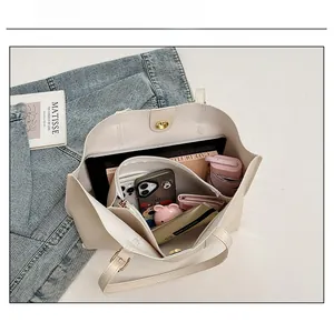 Detailed view of the spacious interior of this beige faux leather tote with daily essentials
