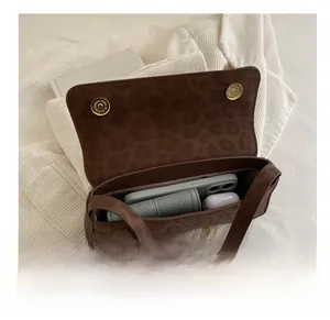 Detail view of the leopard print baguette bag showing capacity for phone and accessories