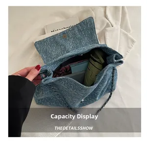 Vue intérieure montrant la grande capacité de ce sac fourre-tout en jean bleu à chaîne