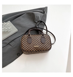 Detail of vintage brown leather handbag with geometric pattern and gold hardware