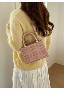 Dettaglio della borsa tote rosa con trama a quadri goffrata e fibbia in metallo oro