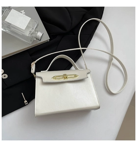 Detailed close-up of cream trapezoid handbag featuring a luxury gold chain metal buckle