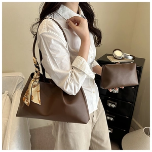 Détail d'un sac cabas marron foncé avec foulard en soie et pochette assortie