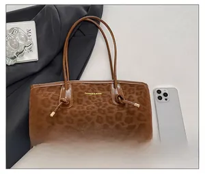 Macro detail of leopard print tote bag with gold logo and decorative side knots