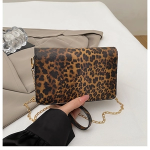 Detailed view of leopard print rectangular purse with golden metal chain strap