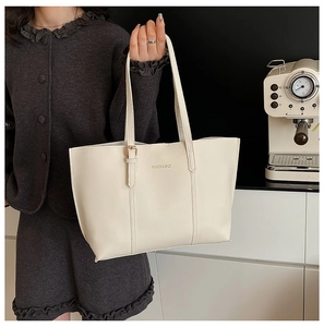 Detail view of cream white tote bag with FASHION & BAGS engraving and gold hardware