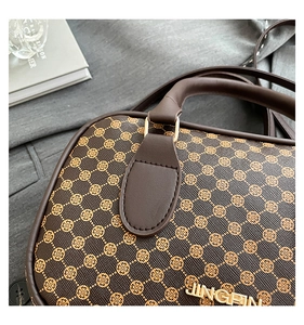 Detailed close-up of brown crossbody bag with clover pattern and gold JINGPIN metal logo