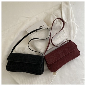 Detail of vintage baguette bags in black and wine red with leopard embossed texture