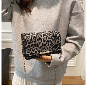 Detail of leopard print handbag featuring a gold chain strap and a metallic lock closure