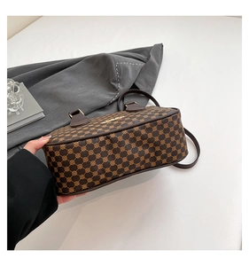 Detail view of the brown monogram crossbody bag showing its bottom and side structure