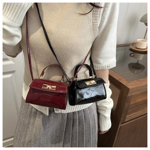 Nahaufnahme glänzender Mini-Taschen mit goldenen Metalldrehverschlüssen und Schultergurten
